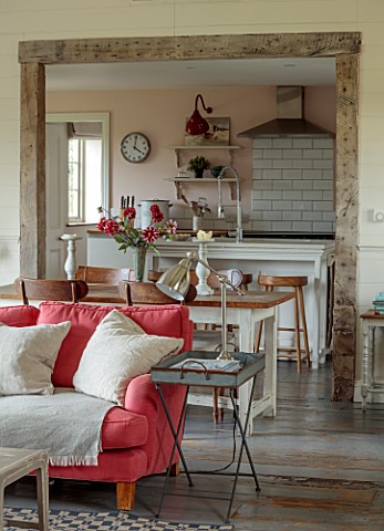 ASHBROOK_HOUSE_NORTHAMPTONSHIRE_LIVING_ROOM_WITH_PINK_RED_SOFA_AND_KITCHEN