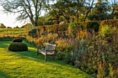 SILVER STREET FARM, DEVON. DESIGNER ALASDAIR CAMERON - LAWN, YEW CONES, BENCHES, SEATS, SEATING, HERBACEOUS BORDER, HEDGES, HEDGING