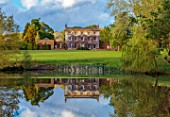 PRIORS MARSTON, WARWICKSHIRE: VIEW ACROSS LAKE, POND, WATER TO HOUSE, SPRING, MAY, HOUSE, REFLECTIONS REFLECTED, CLOUDS