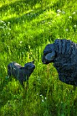 PRIORS MARSTON, WARWICKSHIRE: A SHEEP WITH LAMBS SCULPTURE IN THE WOODLAND