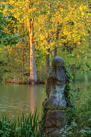 PRIORS_MARSTON_WARWICKSHIRE_WOMAN_STATUE_SCULPTURE_TREES_REFLECTED_IN_THE_WATER_POOL_LAKE_MAY_SPRING