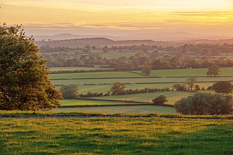 MORTON_HALL_GARDENS_WORCESTERSHIRE_VIEW_FROM_THE_WEST_GARDEN_TO_THE_ABBERLY_HILLS_SUNSET_EVENING_LIG