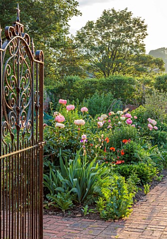 PRIORS_MARSTON_WARWICKSHIRE_THE_MANOR_HOUSE_VIEW_THROUGH_METAL_GATE_INTO_THE_WALLED_GARDEN_WALLS_PEO