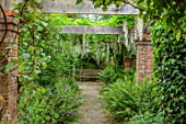 STOCKCROSS HOUSE, BERKSHIRE, PLANTING DESIGN BY ISTVAN DUDAS: WOODEN PERGOLA WITH WOODEN BENCHES, WHITE WISTERIA, FERNS, SHADE, SHADY