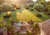 WESTBROOK HOUSE, SOMERSET: DAWN, SUNRISE, TERRACE, PATIO, LAWN, CLIPPED BOX CUBES, PYRUS NIVALIS, SNOW PEAR TREES, BORROWED LANDSCAPE, COUNTRY, GARDEN, SUMMER, TABLE, CHAIRS