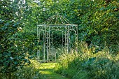 WESTBROOK HOUSE, SOMERSET: ORNATE METAL ARBOUR, GRASS, WOODLAND, WILD, COUNTRY, GARDEN, LAWN, GRASS, PATH, TREES