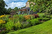 HURDLEY HALL, POWYS, WALES: JULY, LAWN, BORDERS, LYCHNIS CHALCEDONICA, SAMBUCUS, RAISED SEATING AREA, CONSERVATORY