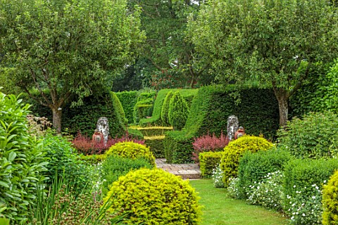 THE_LASKETT_GARDENS_HEREFORDSHIRE_DESIGNER_ROY_STRONG_VIEW_ALONG_GRASS_PATH_STATUES_CLIPPED_TOPIARY_