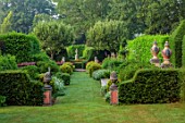 THE LASKETT GARDENS, HEREFORDSHIRE. DESIGNER ROY STRONG: VIEW ALONG GRASS PATH TO SHAKESPEARE MONUMENT, STATUES, CLIPPED, TOPIARY, GREEN, GARDEN, VISTA, HEDGES, HEDGING, JULY