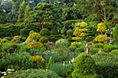 THE LASKETT GARDENS, HEREFORDSHIRE. DESIGNER ROY STRONG - THE SERPENTINE WALK - ACER GRISEUM, CLIPPED, TOPIARY, BOX, HOLLY, ILEX, BUXUS, JULY, SUMMER, YEW HEDGING