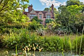 STOCKCROSS HOUSE, HAMPSHIRE: VIEW OF HOUSE ACROSS POND WITH STEPS, SUMMER, AUGUST, WATER, POOL, TREES, ROSES, ROSA CORNELIA, ROMANTIC, ENGLISH, GARDEN