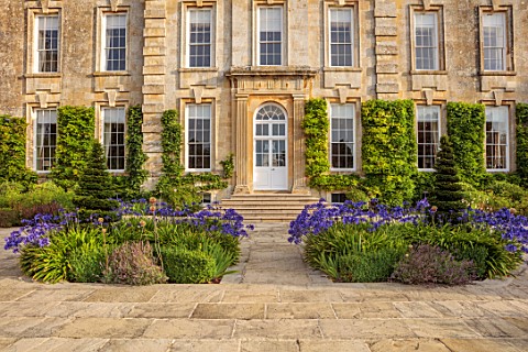 PRIVATE_GARDEN_GLOUCESTERSHIRE__DESIGNER_ANGEL_COLLINS_TERRACE_IN_FRONT_OF_HOUSE_BEDS_BORDERS_BLUE_F