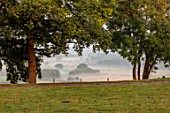 MORTON HALL, WORCESTERSHIRE: THE VIEW WEST BEYOND TREES TO COUNTRYSIDE, TREES, MORNING, DAWN, MIST, FOG, AUGUST, SUMMER