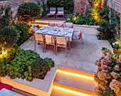 SMALL TOWN, CITY GARDEN DESGNED BY ALASDAIR CAMERON, LONDON: FORMAL, TOWN, GARDEN, NIGHT, LIGHTS, LIGHTING, STEPS, WOODEN BENCH, WALLS, HYDRANGEAS, TABLE, CHAIRS, OUTDOOR LIVING