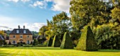 ROCKCLIFFE GARDEN, GLOUCESTERSHIRE: VIEW ACROSS LAWN TO HOUSE, CLIPPED BEECH OBELISKS. ENGLISH, COUNTRY, GARDEN, SEPTEMBER