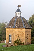 ROCKCLIFFE, GLOUCESTERSHIRE: THE DOVECOTE IN SEPTEMBER, DOVES FLYING AWAY, BUILDING