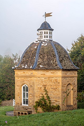ROCKCLIFFE_GLOUCESTERSHIRE_THE_DOVECOTE_IN_SEPTEMBER_DOVES_FLYING_AWAY_BUILDING