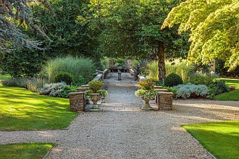 BOWCLIFFE_HALL_YORKSHIRE_DESIGN_ALISTAIR_BALDWIN_GRAVEL_PATH_STONE_WALLS_MAPLE_STONE_URNS_CONTAINERA