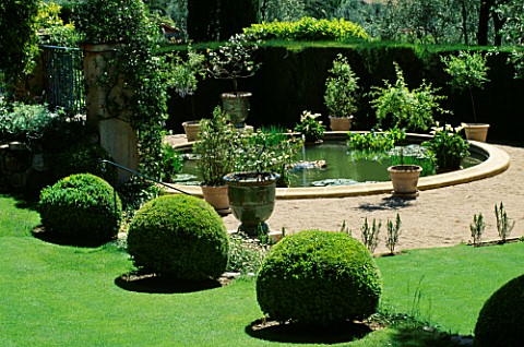 THE_ROUND_BASIN_SURROUNDED_BY_POTS_ON_THE_LOWER_TERRACE_LA_CASELLA__FRANCE_GARDEN_DESIGNED_BY_CLAUS_