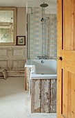 PEAR TREE COTTAGE, OXFORDSHIRE: BATHROOM, FRENCH PANELLED WALLS, WOOD FROM STABLE DOOR WITH BATH SURROUND, VINTAGE, FOXED GLASS FRENCH MIRROR