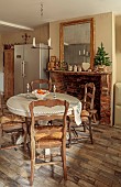 PEAR TREE COTTAGE, OXFORDSHIRE: KITCHEN, VINTAGE WOVEN SEAT CHAIRS, VINTAGE FRENCH TABLE, CABINET, VINTAGE FOXED GLASS MIRROR, VINTAGE TOYS, POTS, CERAMIC CANDLESTICKS