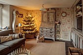 PEAR TREE COTTAGE, OXFORDSHIRE: SITTING ROOM, LUCAS TERRIERS DAVE, NED, CHRISTMAS TREE, FRENCH BUREAU, SWEDISH MORA CLOCK, CUSHIONS, DRUM COFFEE TABLE, CANDLE RING