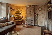 PEAR TREE COTTAGE, OXFORDSHIRE: SITTING ROOM, LUCAS TERRIERS DAVE, NED, CHRISTMAS TREE, FRENCH BUREAU, SWEDISH MORA CLOCK, CUSHIONS, DRUM COFFEE TABLE, CANDLE RING