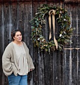 CEST TOUT INTERIORS: THE BARN SHOP, KATHRYN MCFALL, FOUNDER OF CEST TOUT INTERIORS OUTSIDE THE BARN SHOP WITH LARGE FOLIAGEWREATH, FIR, EUCALYPTUS, CYPRESS, LICHENED TWIGS