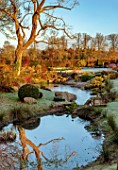 LOWER BOWDEN MANOR, BERKSHIRE: WINTER, JANUARY, POND, POOL, YEW BALLS, CLOUD PRUNED TREE IN WOODEN BOX, CONTAINER, BOULDERS, REFLECTIONS, REFLECTED