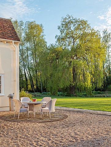 ULTING_WICK_ESSEX_PATIO_BESIDE_HOUSE_WITH_TABLE_CHAIRS_AURICULAS_BY_HOUSE_SPRING_APRIL_WILLOW_TREE_L