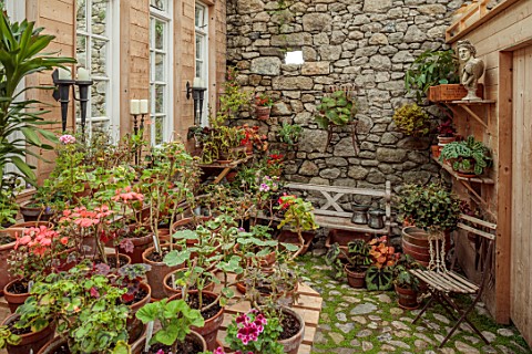 PATTHANA_GARDEN_IRELAND_THE_POTTING_SHED_BEGONIAS_COBBLED_FLOOR_BENCH_SEAT_STONE_WALLS