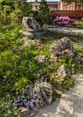 CHELSEA 2022: A SWISS SANCTUARY BY LILLY GOMM: METAL SEAT, BENCH, RHODODENDRONS, GRAVEL PATHS, ROCKS, WATERFALL, POOL, POND