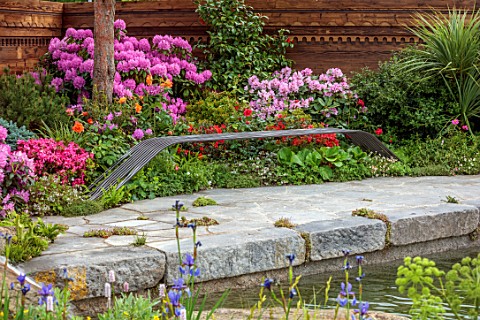 CHELSEA_2022_A_SWISS_SANCTUARY_BY_LILLY_GOMM_POOL_POND_WATER_METAL_SEAT_BENCH_RHODODENDRON_FENCE_FEN
