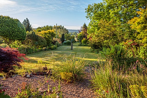 LITTLE_ASH_BUNGALOW_DEVON_VIEW_DOWN_THE_GARDEN_PAST_GRAVEL_BED_TO_LAWN_AND_BORDERS