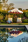 ASHBROOK HOUSE, NORTHAMPTONSHIRE: SUMMER, POOL, POND, WATER, FORMAL, SUN LOUNGERS, SUNLOUNGERS, PARASOL, UMBRELLA BY TITANIA, BORDERS