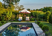 ASHBROOK HOUSE, NORTHAMPTONSHIRE: SUMMER, POOL, POND, WATER, FORMAL, SUN LOUNGERS, SUNLOUNGERS, PARASOL, UMBRELLA BY TITANIA, BORDERS