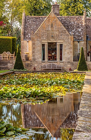 THE_SUMMERHOUSE_OXFORDSHIRE_JULY_SUMMER_VIEW_ALONG_CANAL_POND_POOL_WATER_GARDEN_TO_HOUSE_YEW_PYRAMID
