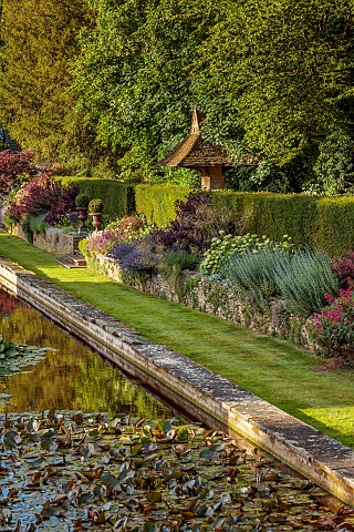 THE_SUMMERHOUSE_OXFORDSHIRE_JULY_SUMMER_CANAL_POND_POOL_WATER_GARDEN_BORDERS_TREES_WATERLILIES_STONE
