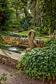YORK GATE, YORKSHIRE: HORIZONTAL CLIPPED, ESPALIERED CEDAR, RAISED POOL, WATER, FOUNTAIN, GREEN, JULY, CANAL, WATER FEATURE