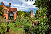 STOCKCROSS HOUSE, BERKSHIRE: VIEW FROM PERGOLA, LAWN, BORDERS, CANNA LEAVES, FENNEL, CHURCH, BORROWED LANDSCAPE