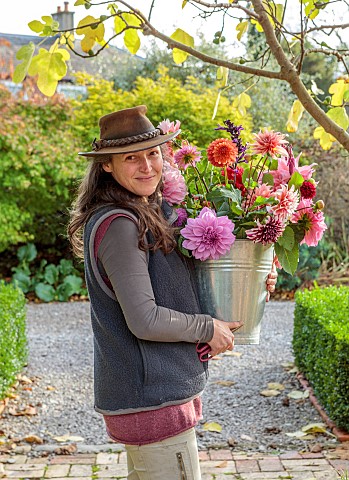 THE_LAUNDRY_GARDEN_DENBIGH_WALES_JENNY_WILLIAMS_HOLDING_CONTAINER_OF_DAHLIAS_BY_FIG_BESIDE_THE_WALLE