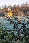 ROCKCLIFFE GARDEN, GLOUCESTERSHIRE: CLIPPED TOPIARY YEW BIRDS, DOVECOTE, BUILDING, ORCHARD, FROST, FROSTY, SUNRISE