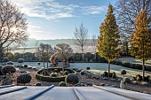 ORDNANCE HOUSE, WILTSHIRE: FROST, FROSTY, WINTER, CLIPPED TOPIARY STANDARDS, PORTUGUESE LAUREL, PRIVET, FORMAL, COUNTRY, GARDEN, GRAVEL, PATHS, HEDGES, HEDGING, PYRUS CHANTICLEER