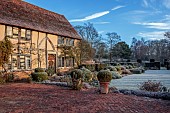 LONG BARN GARDENS, KENT: FROST, WINTER, HOUSE, TERRACE, CONTAINERS, LAWN, AVENUE OF IRISH YEWS, CLIPPED TOPIARY