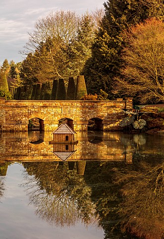 THENFORD_GARDENS__ARBORETUM_NORTHAMPTONSHIRE_LAKE_BRIDGE_AND_THE_RILL_BEYOND_IN_FEBRUARY_TREES_WATER