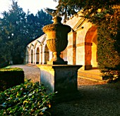 GOLDEN LIGHT OF DAWN: CLASSIC STONE URN IN F/G AND BEHIND IT THE ARCADE VIEWPOINT KNOWN AS PRAENESTE AT ROUSHAM  OXFORDSHIRE
