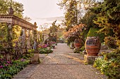 IFORD MANOR, WILTSHIRE: APRIL: SUNSET, TERRACE, CLASSICAL, COUNTRY, GARDEN, CHERRY, URNS, POTS, CONTAINERS, TULIPS, ITALIANATE, DESIGNER HAROLD PETO