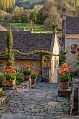 IFORD MANOR, WILTSHIRE: APRIL: STEPS TO TOP TERRACE, TERRACOTTA CONTAINERS WITH TULIPS, LANDSCAPE, BORROWED LANDSCAPE