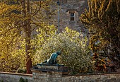 IFORD MANOR, WILTSHIRE: APRIL: VIEW FROM THE KITCHEN, VEGETABLE GARDEN, WALLS, STATUE OF DYING GAUL, BLOSSOM OF EXOCHORDA X MACRANTHA THE BRIDE