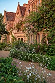 ASTHALL MANOR, OXFORDSHIRE: FRONT OF MANOR, PINK, ROSES, ROSA CECILE BRUNNER, OX EYE DAISIES, ASTRANTIAS, WALLS, DAWN, SUNRISE